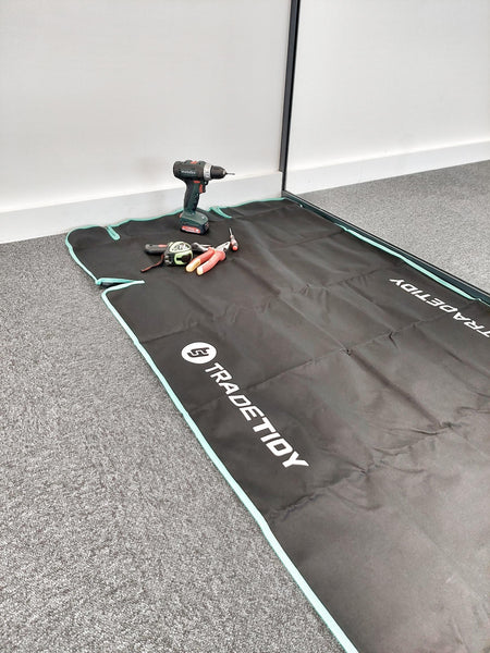 Black mat with 'TradeTidy' branding on a grey floor.
