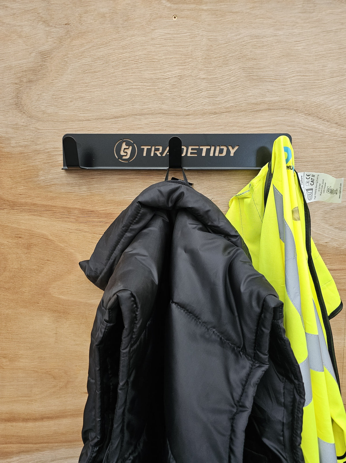 TradeTidy - Black Coat Hanger mounted on a wooden wall with jacket hanging (view 2)