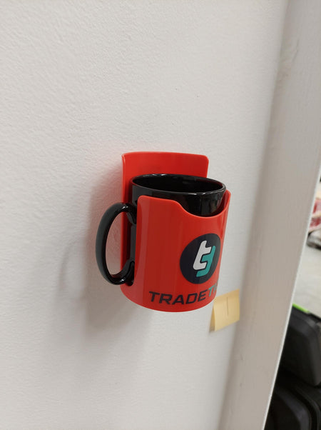TradeTidy - black mug in a red magnetic cup holder mounted on a wall