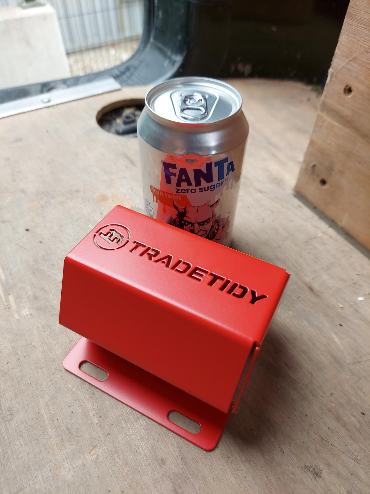 TradeTidy - Red can holder next to a Fanta can on a wooden surface