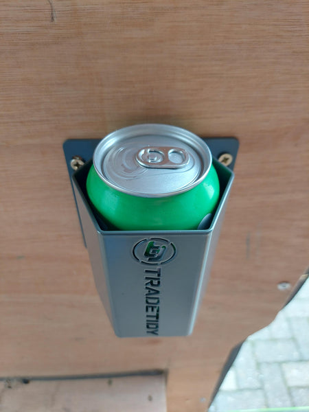 Green can inserted into a can holder labeled 'TradeTidy' on a wooden surface.