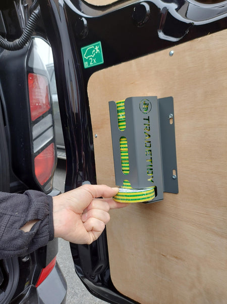 Hand holding a roll of green and yellow tape next to a metal bracket with 'TradeTidy' branding.