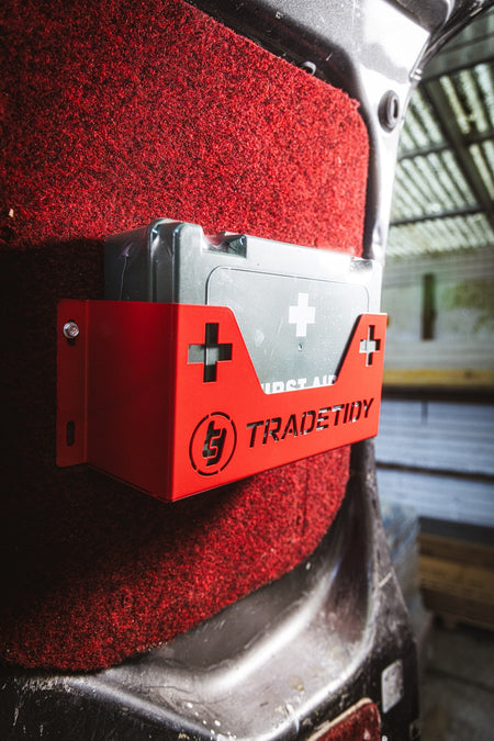 first aid kit in a red first aid kit holder with 'TradeTidy' branding mounted on a workshop van's door