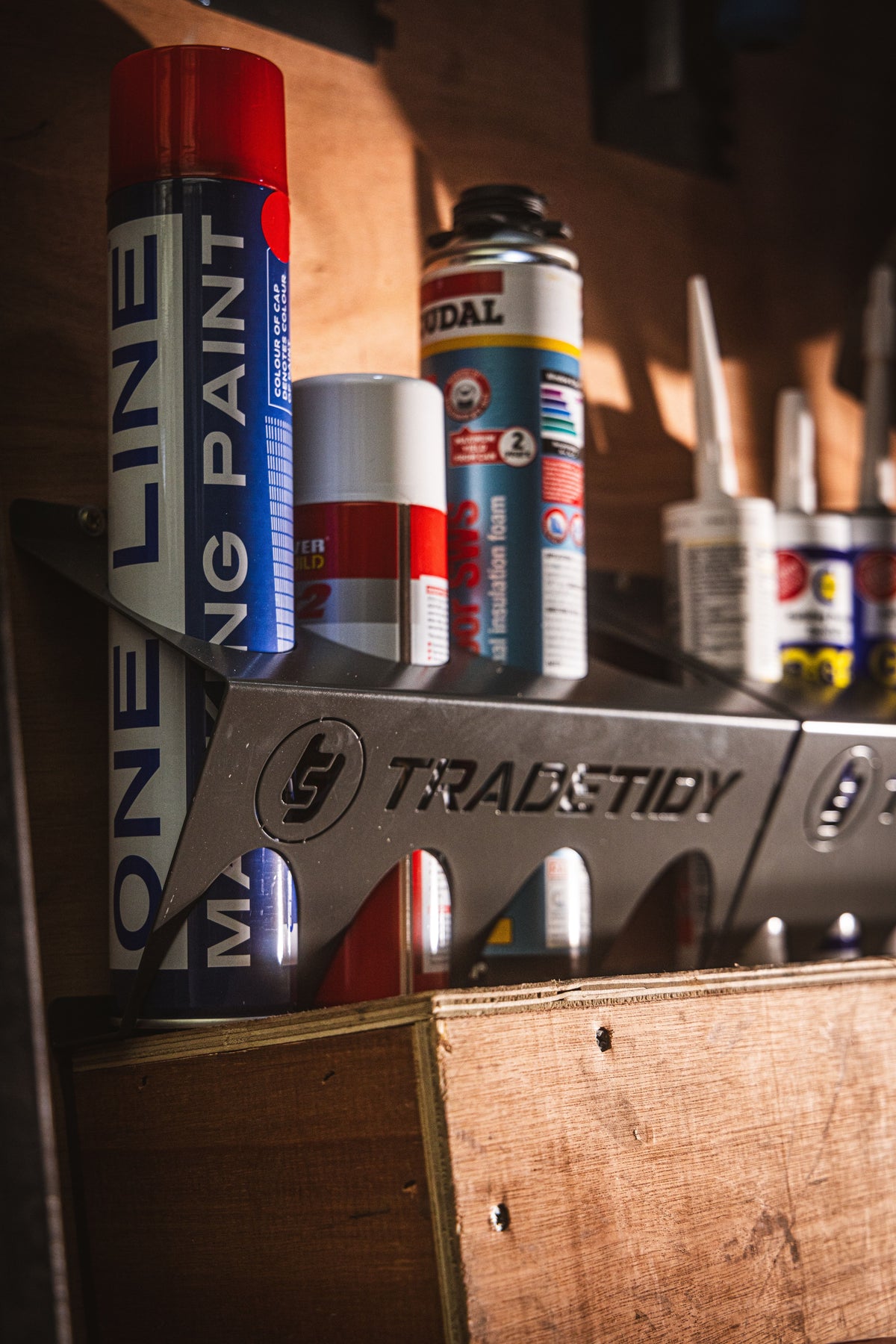 TradeTidy - Spray Cans in a Black Can Holder mounted on a Wooden Wall