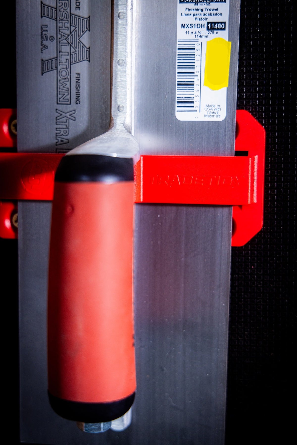 Close up image of a trowel in a trowel TradeTidy holder organised hanging on a wall