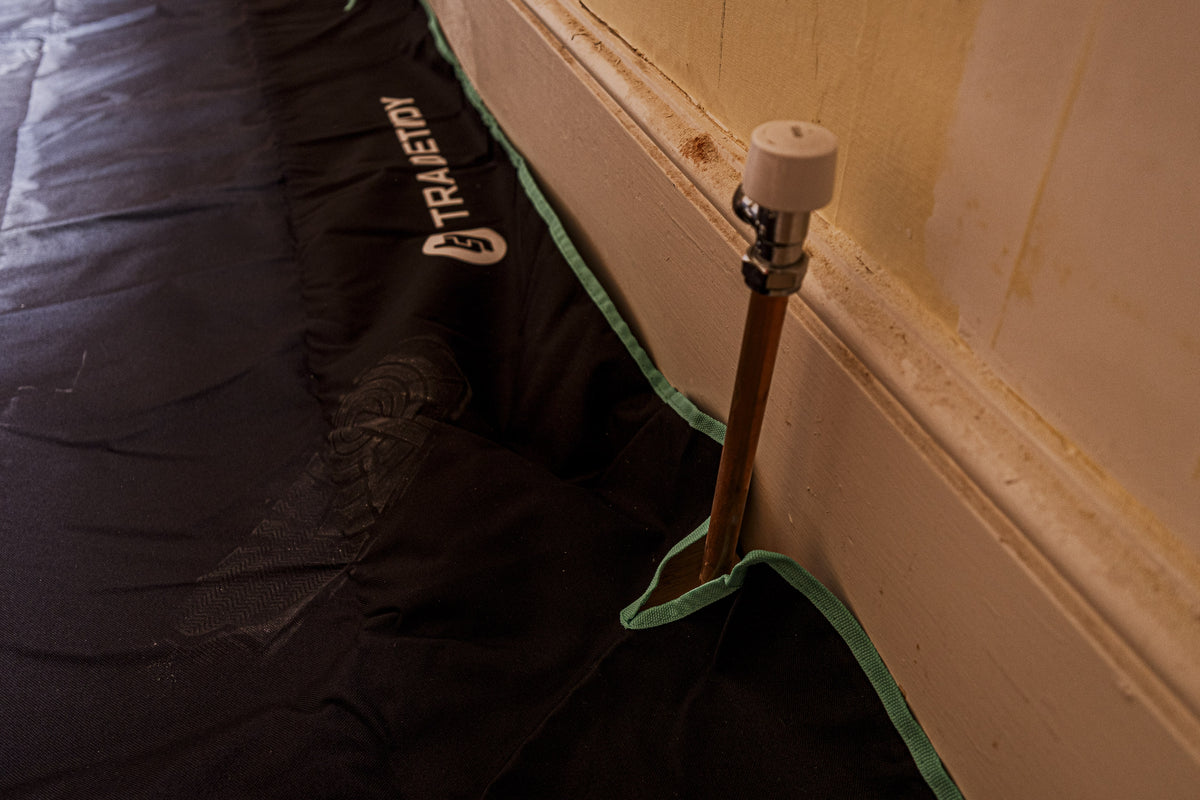 TradeTidy - Close-up of a black work bag with a brand logo on a wooden floor.