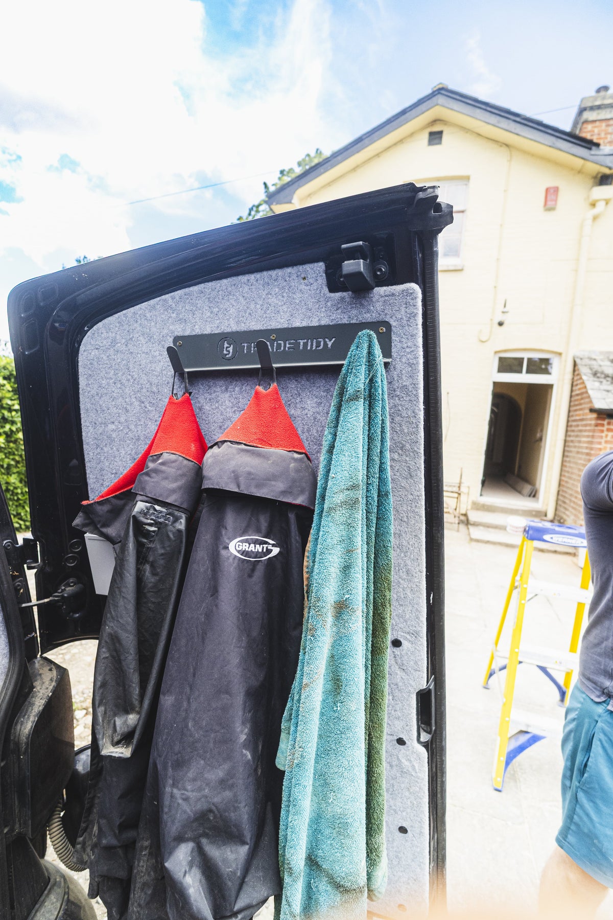TradeTidy - Black Coat Hanger mounted on a workshop van with jackets and towel hanged