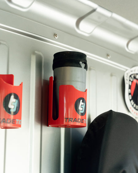 TradeTidy - grey tumbler with a black lid in a red magnetic cup holder mounted on a wall