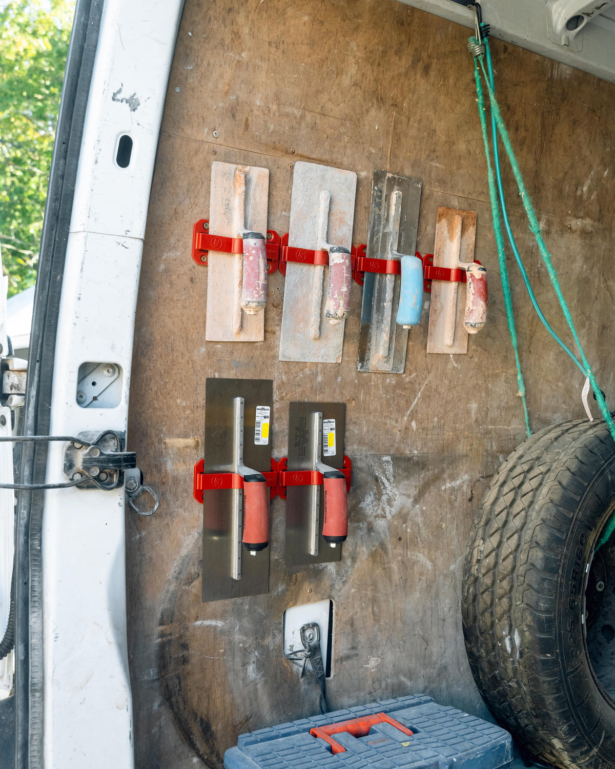 TradeTidy - Trowel Holders mounted on a wall, holding various trowels, with a focus on the holders in the center.