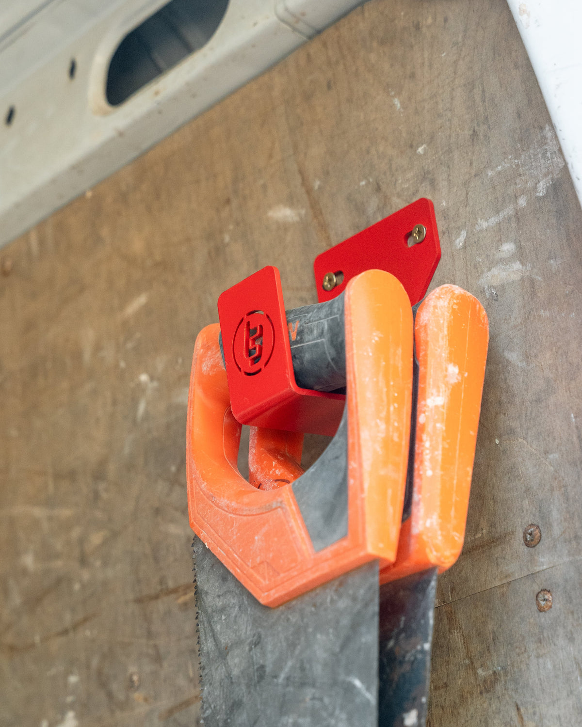 TradeTidy - Saw hanging on a red general purpose hook mounted on a workshop van