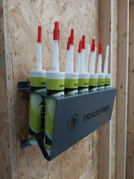 TradeTidy - silicone tubes in a grey silicone tube holder hanging on a wooden wall