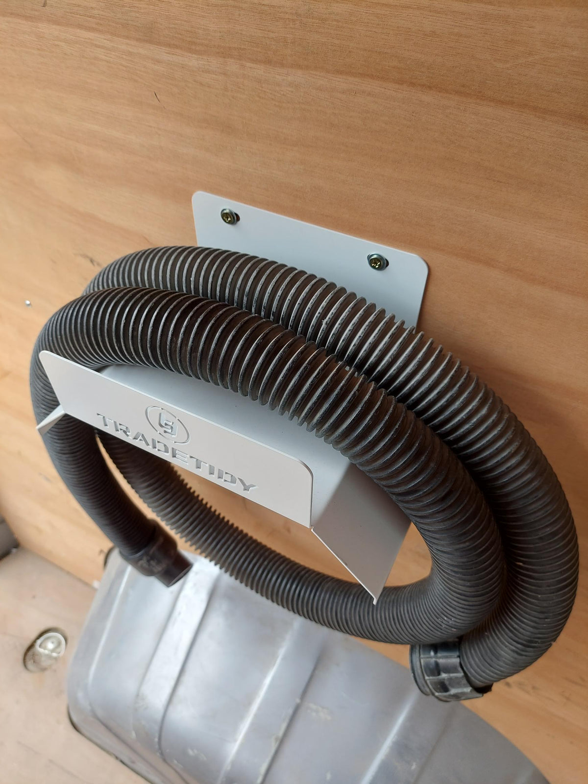 TradeTidy - Hose hanging on a white Hose Holder mounted on a wooden wall (view 2)